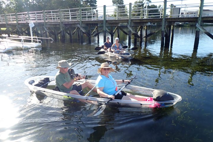 a group of people riding on the back of a boat in the water