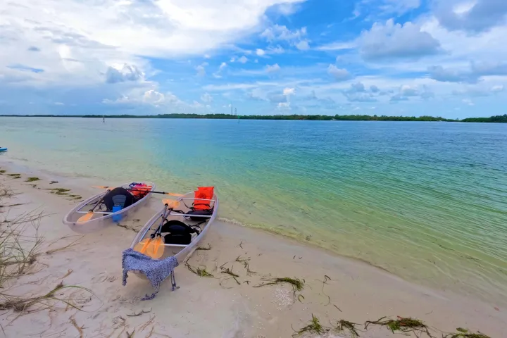 a boat sitting on top of a beach next to a body of water