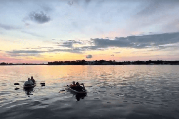a group of people in a small boat in a body of water